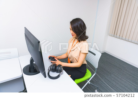 Image of operator work: Image of female staff performing remote control using a controller in the work room Image of operator work: Image of female staff performing remote control using a controller in the work room 57104212