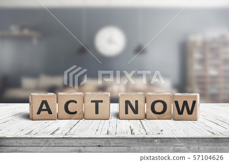 Act now message sign on a wooden desk 57104626