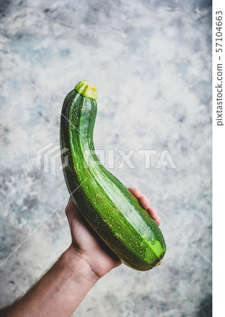 Hand holding zucchini 57104663