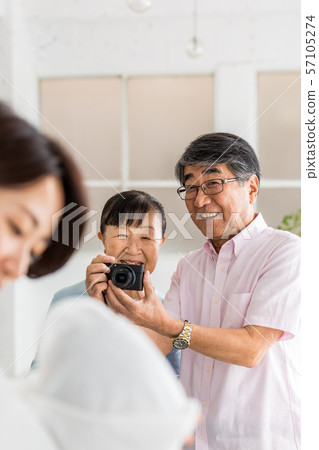 拍他們的孫的照片資深夫婦與一台數字照相機 拍他們的孫的照片資深夫婦與一台數字照相機 57105274