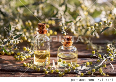 Bottles of essential oil with blooming wormwood 57105471