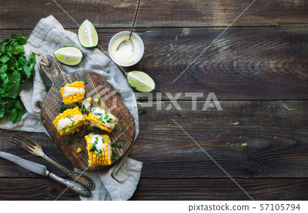 Baked corn cobs with aioli sauce and cilantro Baked corn cobs with aioli sauce and cilantro 57105794