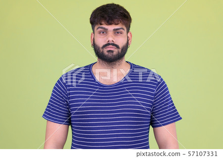 Young overweight bearded Indian man looking at camera Young overweight bearded Indian man looking at camera 57107331