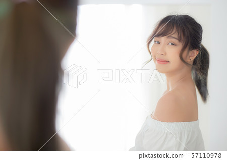 Beautiful young asian woman smiling with clothes trying on dressed up fitting Beautiful young asian woman smiling with clothes trying on dressed up fitting 57110978