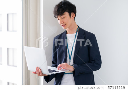 Man business laptop standing at the window Man business laptop standing at the window 57113219