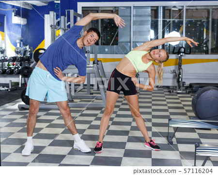 Couple stretching before workout at gym Couple stretching before workout at gym 57116204