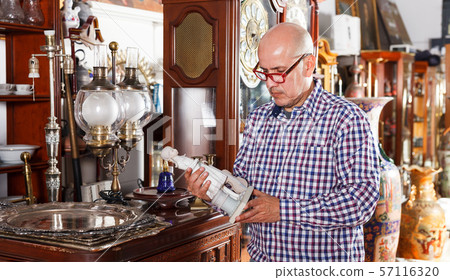 Man choosing ancient things in store Man choosing ancient things in store 57116320