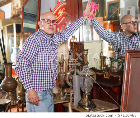 vendor wiping dust on ancient items 57116465