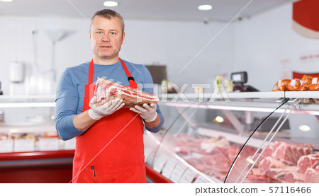 Positive man seller showing fresh meat 57116466