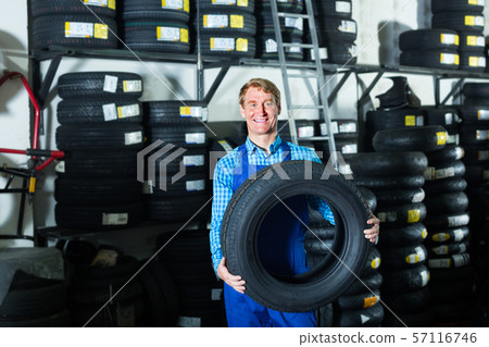 man working with new tyre for car 57116746