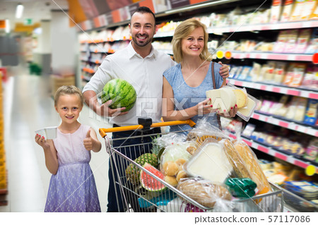 Young parents with girl shopping in hypermarket Young parents with girl shopping in hypermarket 57117086
