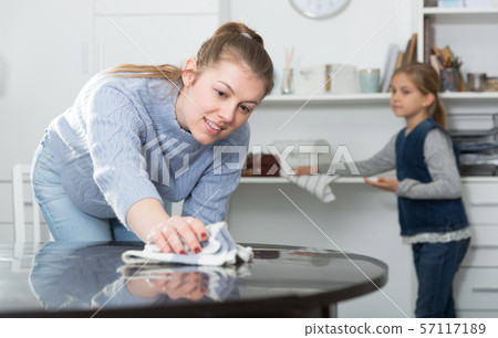 Woman with vacuum cleaner and daughter with rag Woman with vacuum cleaner and daughter with rag 57117189