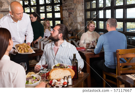 Rustic restaurant owner serving guests 57117667