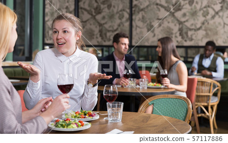 Happy girl with female friend in restaurant Happy girl with female friend in restaurant 57117886