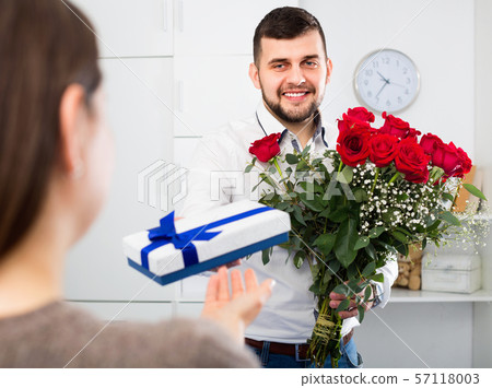 Man ready to present flowers and gift at holiday 57118003