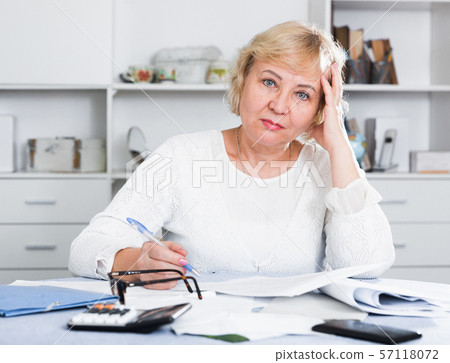 Woman engaged in home accounting Woman engaged in home accounting 57118072