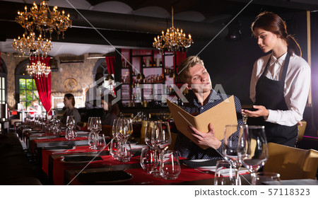 Man holding menu and ordering food 57118323