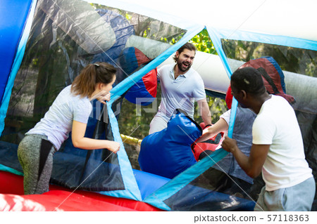 Gambling friends boxing giant gloves on an inflatable trampoline in an amusement park Gambling friends boxing giant gloves on an inflatable trampoline in an amusement park 57118363