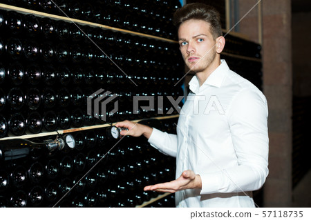 Male worker checking secondary fermentation of wine 57118735