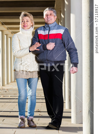 Laughing husband and wife are walking together 57118917