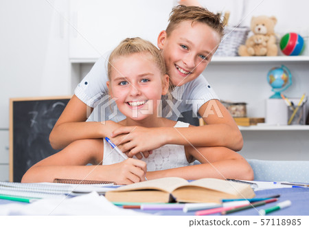 Boy is helping girl doing homework Boy is helping girl doing homework 57118985