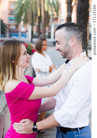 Cheerful couple are talking and woman is envying them Cheerful couple are talking and woman is envying them 57119166