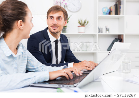 Business colleagues sitting with laptops 57119267