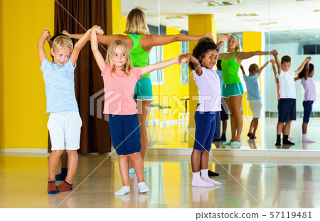 Group of tweens exercising folk dance, forming circle with femal 57119481