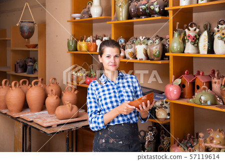 Girl showing finished ceramic production Girl showing finished ceramic production 57119614