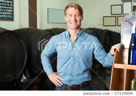 man in cellar with wine woods . 57119994