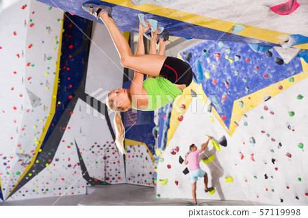 Woman climbing artificial rock in gym Woman climbing artificial rock in gym 57119998