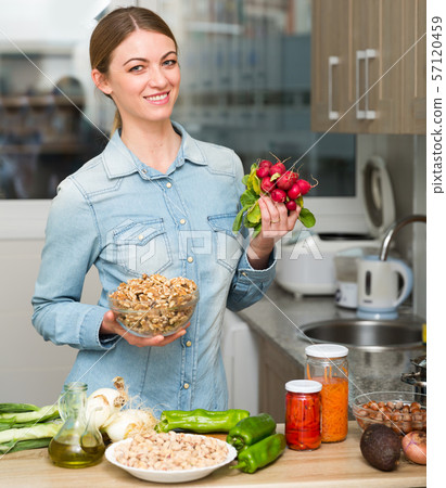 Smiling housewife cooking dinner in the kitchen at home 57120459