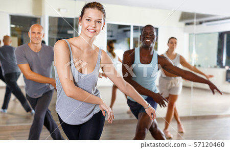 Cheerful people practicing vigorous lindy hop movements in dance class 57120460