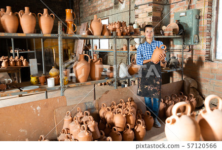 Woman chooses pots clay pots in store warehouse 57120566