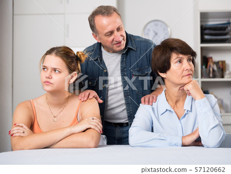 Adult male is talking with his wife and daughter to reconciles them Adult male is talking with his wife and daughter to reconciles them 57120662