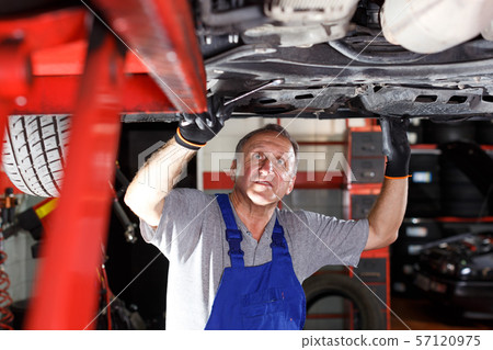 Mechanic engaged in car repair Mechanic engaged in car repair 57120975