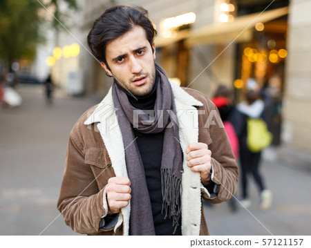 Adult man in winter coat standing in the historical city center 57121157