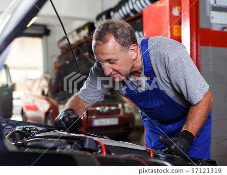 Mechanic checking and replacing motor oil 57121319