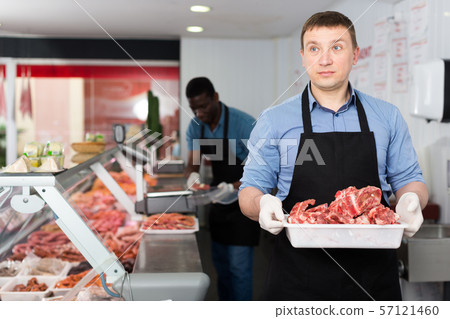 Butchers working behind counter 57121460