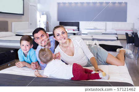 parents with two young sons testing mattress in store parents with two young sons testing mattress in store 57121462
