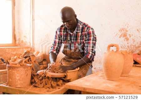 Man making ceramics on pottery wheel 57121529