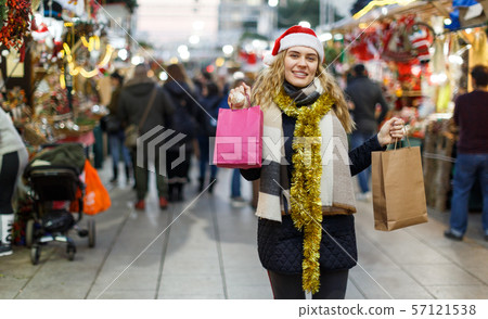 Cheerful girl near Christmas fair shops Cheerful girl near Christmas fair shops 57121538