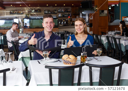 Couple and reading menu in restaurant Couple and reading menu in restaurant 57121678