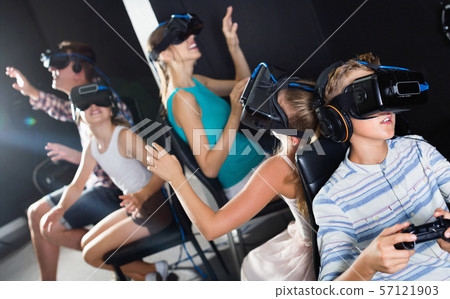 Family of five is watching VR together in the room. Family of five is watching VR together in the room. 57121903