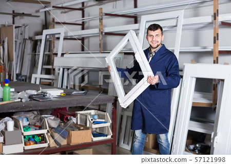 hardworking male professional labours with finished PVC profiles and windows hardworking male professional labours with finished PVC profiles and windows 57121998
