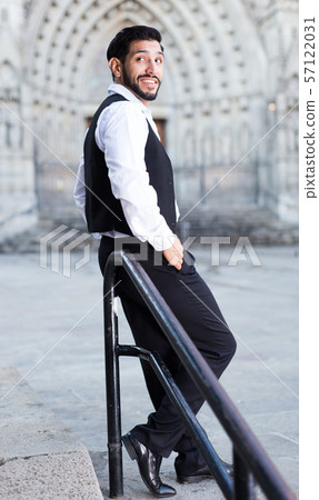 Confident man posing near iron banisters Confident man posing near iron banisters 57122031