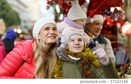 Parents with daughters choosing Christmas toys Parents with daughters choosing Christmas toys 57122188