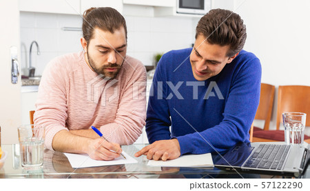 Men discuss and sign apartment sale contract agreement at home Men discuss and sign apartment sale contract agreement at home 57122290