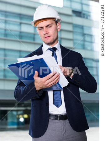 Architector in suit and hat is looking into documents with project Architector in suit and hat is looking into documents with project 57122291