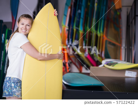 Portrait of happy young female with surfboard Portrait of happy young female with surfboard 57122422